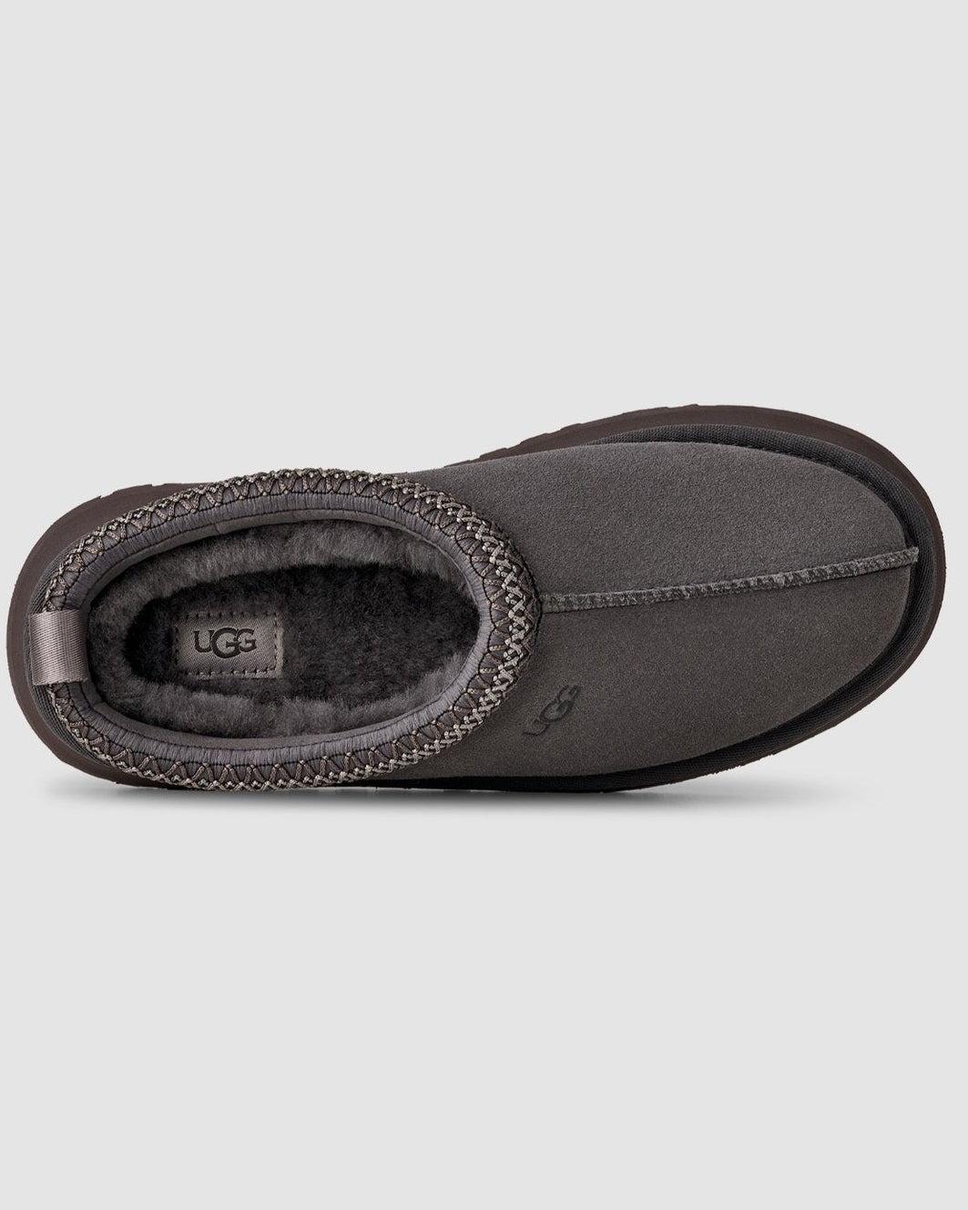 Dark gray UGG slipper on a light gray background